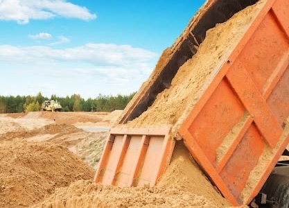 Самосвал высыпает песок на карьере